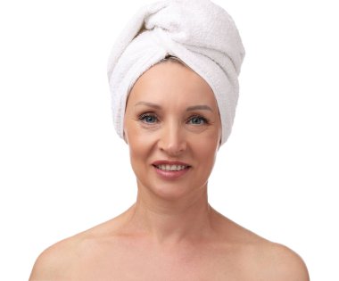 Beyaz arka planda kafasına havlu sarılmış güzel bir kadın.