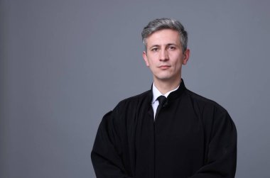 Gri arka planda mahkeme elbisesi giyen yargıç. Metin için boşluk