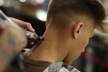 Profesyonel berber berber dükkanında şık saç kesimi yapıyor, yakın plan.