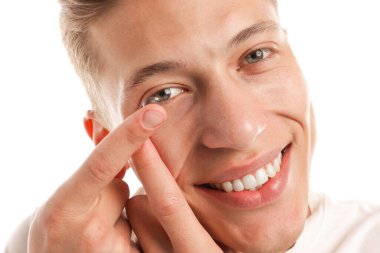 Beyaz arkaplana kontak lens takan adam, yakın plan