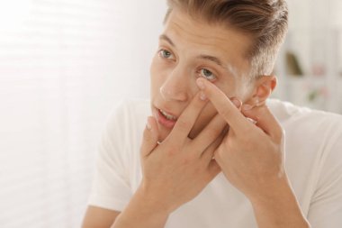 Evde kontak lens takan adam