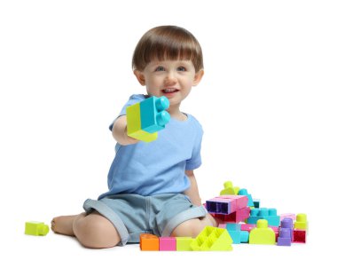 Beyaz arka planda tuğlalarla oynayan sevimli küçük çocuk.