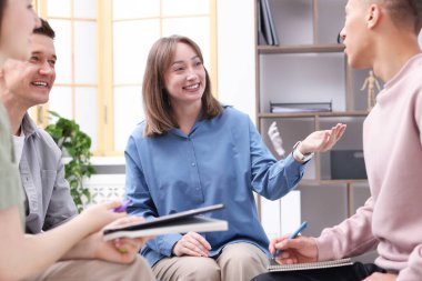 Yaşam koçluğu dersinde kapalı alanda toplantı yapan bir grup insan.