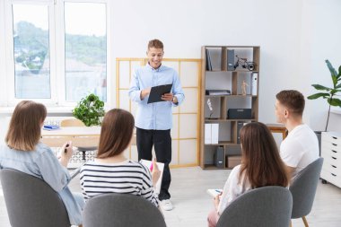 Yaşam koçluğu dersinde kapalı alanda toplantı yapan bir grup insan.