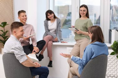 Yaşam koçluğu dersinde kapalı alanda toplantı yapan bir grup insan.