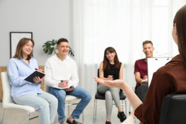 Yaşam koçluğu dersinde toplanan bir grup insan kapalı alanlarda seçici bir şekilde odaklanıyor.