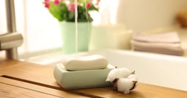 İçerideki ahşap masada sabun ve pamuk çiçeği, seçici bir odak.