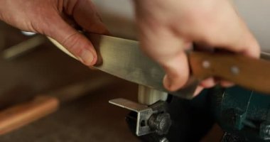 Bıçak keskinleştiren adam içeride, yakın plan.