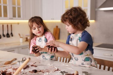 Yemek tarifi. Küçük çocuklar mutfaktaki masada kurabiye için para kazanıyorlar.