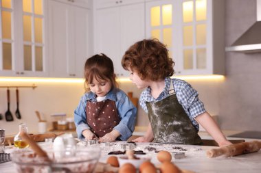 Yemek tarifi. Küçük çocuklar mutfaktaki masada kurabiye için para kazanıyorlar.