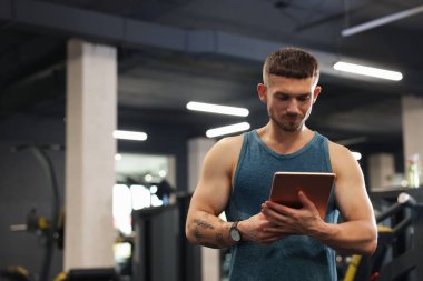 Spor merkezinde tableti olan kişisel antrenör. Metin için boşluk