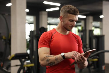 Spor merkezinde tableti olan kişisel antrenör.