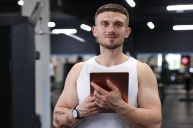 Spor merkezinde tableti olan kişisel antrenör.