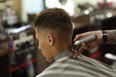 Berber dükkanında müşteriyle çalışan profesyonel berber, yakın plan.