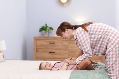 Mutlu anne oğluyla evde yatakta vakit geçiriyor.