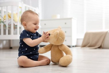 Odada oyuncak ayıyla oynayan şirin bir bebek, mesaj atmak için yer var.