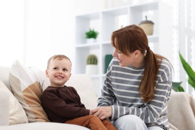 Mutlu anne oğluyla evdeki kanepede vakit geçiriyor.