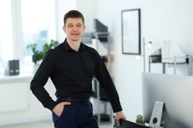 Ofisteki masanın yanındaki yakışıklı adamın portresi.