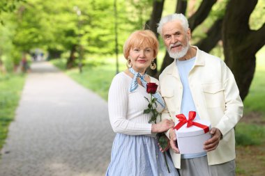 Hediye kutusu olan ve parkta gül gülü olan sevimli son sınıf çifti, mesaj için yer var.