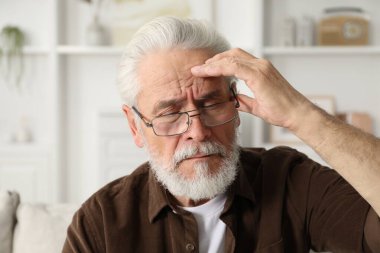 Yaşlı adam evde göz yorgunluğu çekiyor.