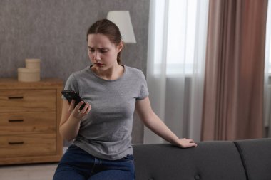 Depresyondaki kadın evdeki kanepeden ruh sağlığı için yardım hattını arıyor. Metin için boşluk