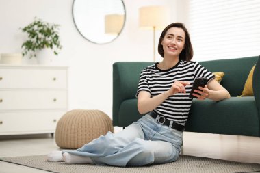 Evde modern akıllı telefon kullanan bir kadın. Metin için boşluk