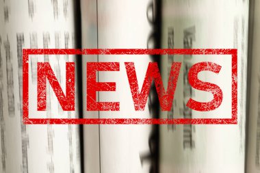 Kırmızı Haber damgası ve arka plan olarak gazeteler, yakın plan