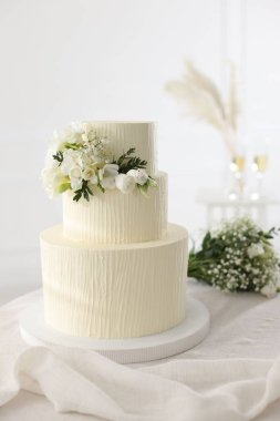 Çiçekli düğün pastası ve kapalı masa desenli lezzetli bir pasta.