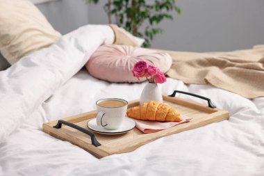 Nefis bir kahvaltı tepsisi ve kapalı bir odada çiçekler, yakın plan. Metin için boşluk