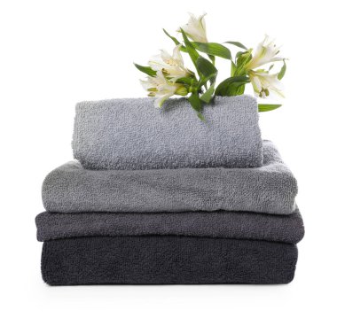 Havlu yığını ve beyaz üzerine izole edilmiş güzel çiçekler.