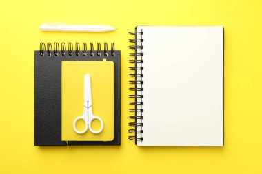 Düz kompozisyon, sarı arkaplanda boş bir defter.