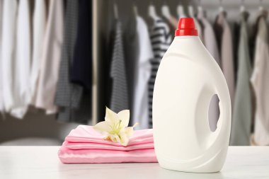 Kumaş yumuşatıcı ve temiz çamaşırlar masadaki gardıroba karşı.