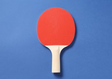 Mavi arka planda bir ping pong raketi, üst görünümde.