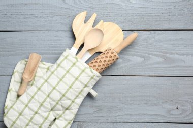 Fırın eldivenindeki farklı mutfak aletleri açık gri ahşap masa, üst manzara. Metin için boşluk