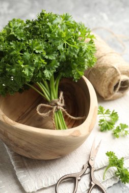 Taze maydanoz, iplik ve makas gri desenli masa, yakın plan.