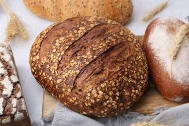 Taze ekmek somunları ve çiviler beyaz masada, yakın plan.