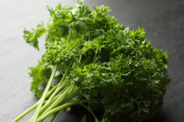 Gri masada taze maydanoz var, yakın plan.