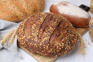 Taze ekmek somunları ve çiviler beyaz masada, yakın plan.