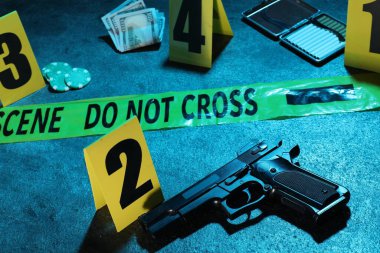 Adli tıp uzmanlığı. Deliller, işaretler ve mavi arka planda polis bandı olan suç mahalli, yakın plan. Renkli tonlama efekti