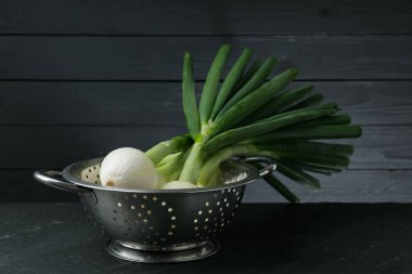 Siyah masada taze taze taze taze soğan kevgir.