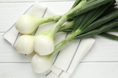 Taze taze soğan ve beyaz ahşap masa üzerinde havlu.