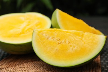 Hasır masada olgun sarı karpuz parçaları, yakın plan.