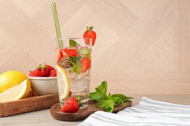 Çilekli, limonlu, ahşap masadaki nane şekerli, ferahlatıcı bir içecek.