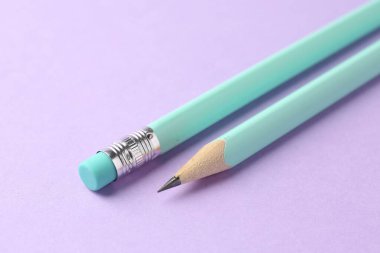 Menekşe arkaplanda iki grafit kalem, yakın plan.