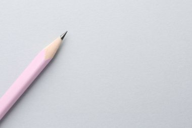 Açık gri arka planda bir grafit kalem, üst manzara. Metin için boşluk