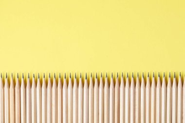 Sarı arka planda bir sürü grafit kalem var. Metin için boşluk