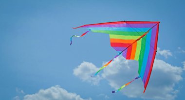 Mavi gökyüzünde uçan renkli uçurtma, alt manzara. Metin için boşluk