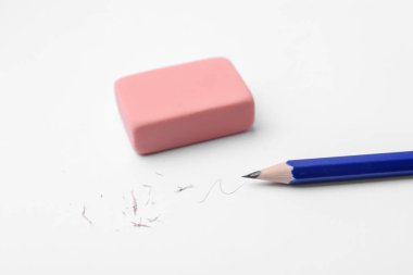 Beyaz arkaplanda kalem, silgi, karalama ve kırıntılar, yakın plan