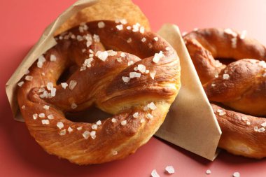 Kırmızı arkaplanda tuzlu krakerler, yakın plan.