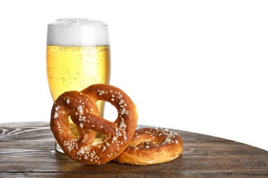 Lezzetli krakerler ve beyaz arka plandaki ahşap masada bir bardak bira. Metin için boşluk